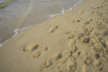 Mediterranean scene, shore of the Mediterranean Sea with barefoot footprints of people in summer