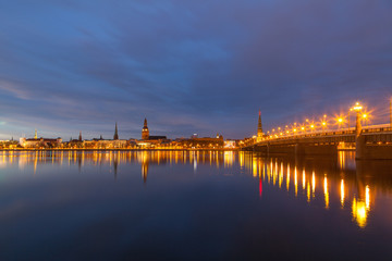 Fototapeta premium Skyline of old town of Riga seen across the river Daugava with the stone bridge at night.