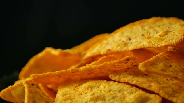 4K UHD footage of triangle nacho chips slowly rotating, close up