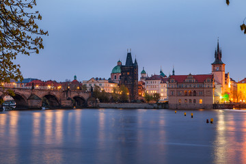 Fototapeta na wymiar View of night old town of Prague and Charles bridge with reflection in Vltava River