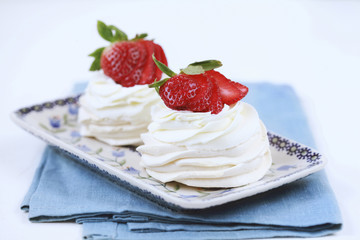 Three homemade mini cakes with meringue (pavlova) and cream cheese with strawberries. Selective focus.