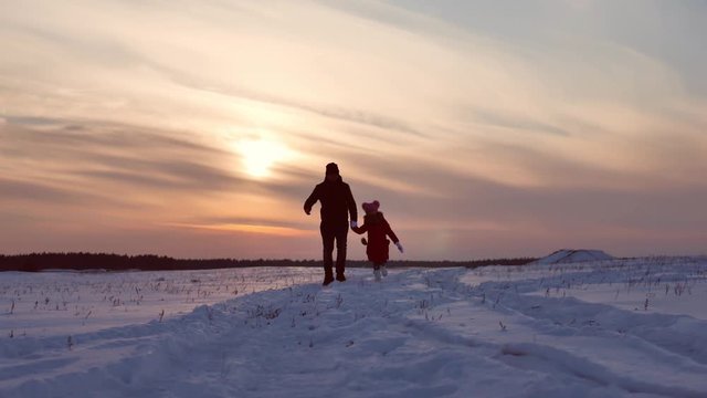 Beautiful sunset, father and daughter running to the sunset, winter.