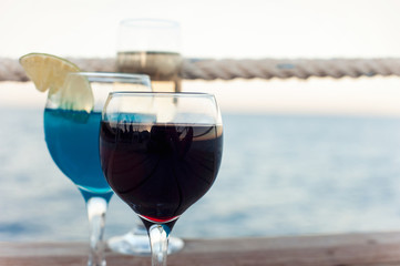 Two glasses with red wine and fresh blue cocktail drink