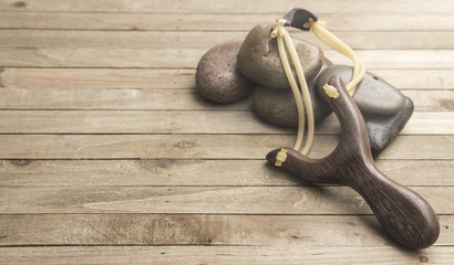 Slingshot Representing the Fight Between David and Goliath on a Wooden Table