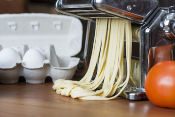 Fototapeta na wymiar machine for rolling dough and cutting Italian pasta, eggs and flour