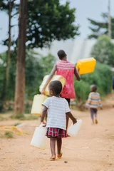 Fotobehang Afrika Child carrying water cans in Uganda africa  © Dennis
