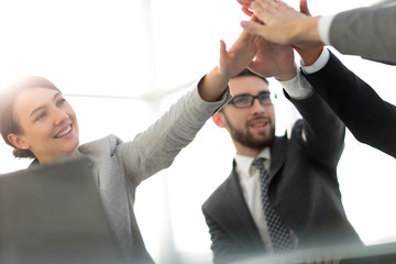 happy business team giving high five in office