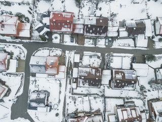 Aerial view of rooftops of German town in winter. Everything covered with snow