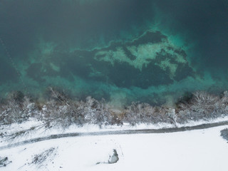 Aerial view of lake in winter with snow covered border