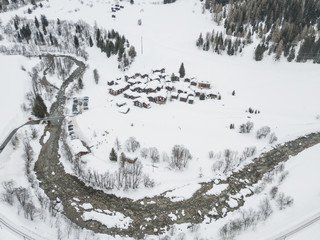 Fototapeta na wymiar Aerial view of snow covered rooftops in mountain village in winter