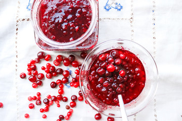 Jam bank with berries top view on a white tablecloth