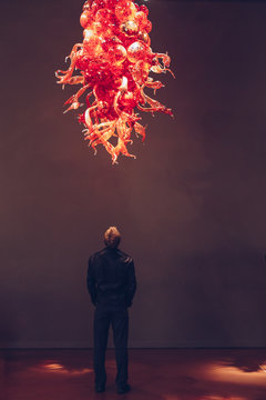 Man in Art Museum looking at Glass Sculpture 