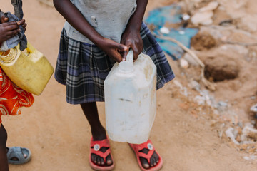 Child carrying water can in Uganda Africa