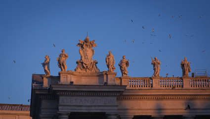 Obraz premium St. Peter's Basilica Saint Statues on the Colonnades during sunset