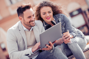 Young couple using a laptop outdoors