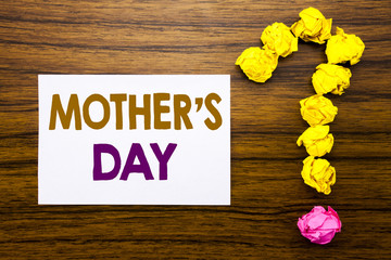 Fototapeta premium Handwritten text showing Mother Day. Business concept for Mom Greetings Celebration Written on sticky note paper, wooden background with question mark from sticky note. For asking questions.