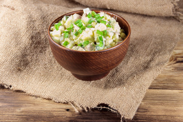 Traditional Russian festive salad Olivier on wooden table