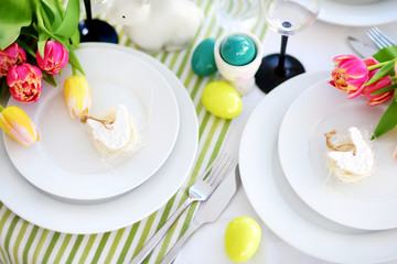 Beautiful table setting with crockery and flowers for Easter celebration