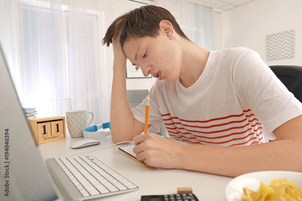 Canvas Prints Tired teenager boy doing homework indoors