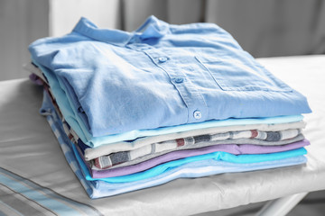 Stack of laundry on ironing board, indoors