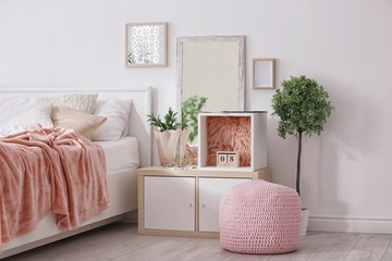 Cozy bedroom interior with shelving unit used as wardrobe