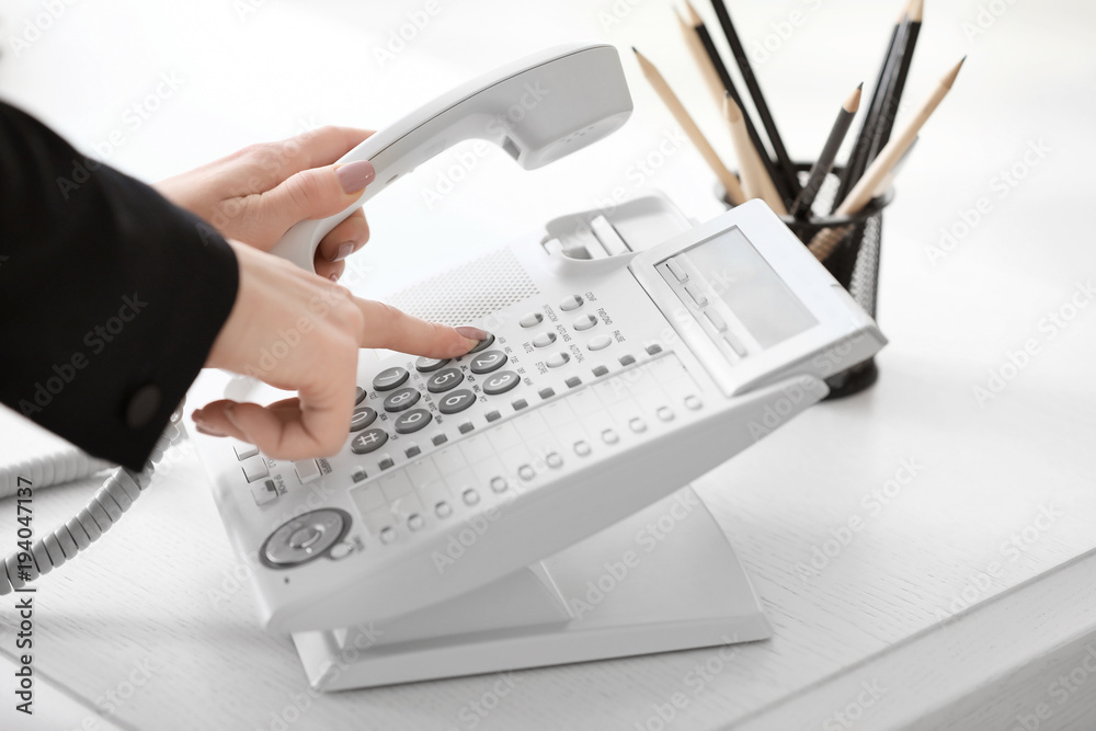 Wall mural woman using landline phone in office, closeup