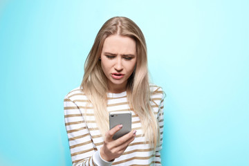 Fototapeta premium Beautiful woman using mobile phone on color background