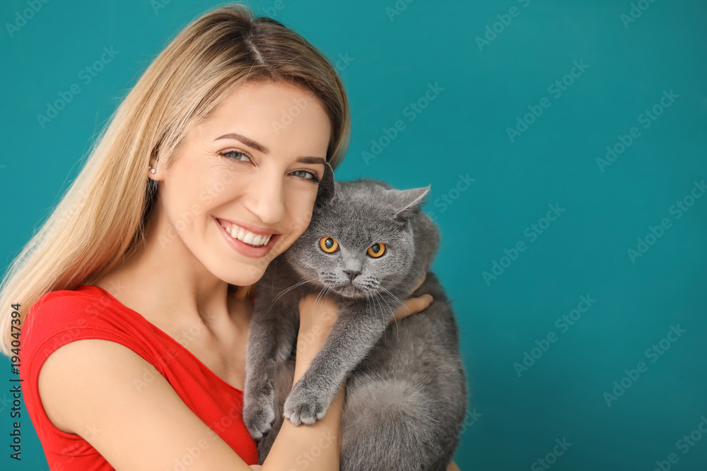 Canvas Prints Young woman with cute pet cat on color background