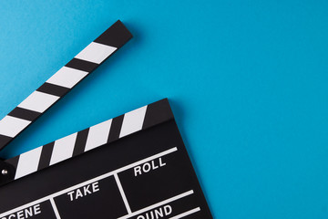 Movie clapper board on blue background with copy space, close-up, view from above. Cinema and movie...
