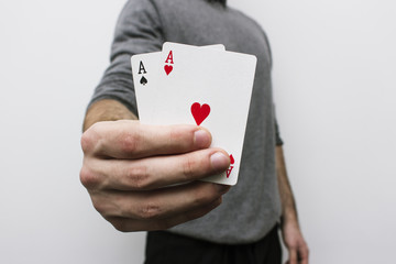 Man holding two plastic cards(aces)