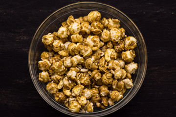 Obraz na płótnie Canvas Sweet popcorn on the black background. Popcorn in the bolw. Snack for the movies. Cinema set.