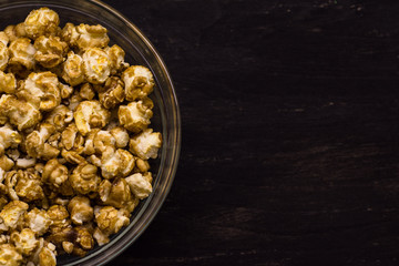 Sweet popcorn on the black background. Popcorn in the bolw. Snack for the movies. Cinema set.
