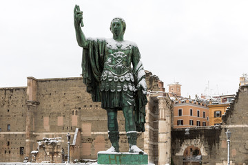 Fototapeta na wymiar Snow covers the streets of Rome, Italy. Statue of Nerva.