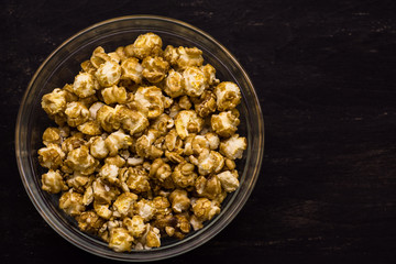 Sweet popcorn on the black background. Popcorn in the bolw. Snack for the movies. Cinema set.