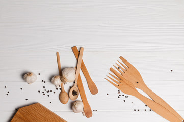 Fresh sliced garlic in glass bowl on wooden background.