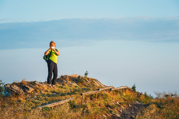 Obraz premium woman stands on the top and admires the beautiful sunrise