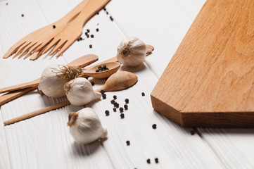 Fresh sliced garlic in glass bowl on wooden background.