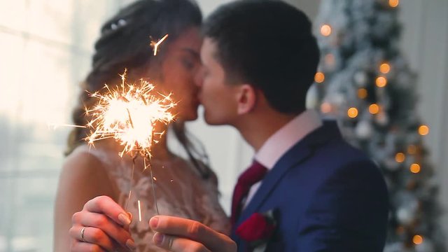 Beautiful young loving wedding couple in new year interior with Bengali lights