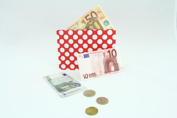 Banknoty EURO w czerwonej kopercie w białe kropki © Cezzar