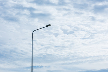 street lamp pole light against the white clouds sky