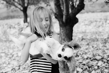 7 year old girl is walking with a puppy in the park