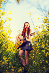 Young ginger hair girl in 70s style with acoustic guitar