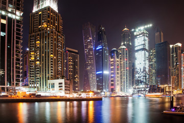 Fototapeta na wymiar DUBAI, UAE - FEBRUARY 2018: Colorful evening on canal and promenade in Dubai Marina,Dubai,United Arab Emirates