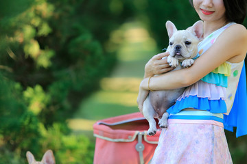 Portrait Of A Young Woman holding a French bulldog in her arms. With copy space.