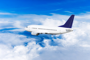 Naklejka na ściany i meble Airplane over the clouds