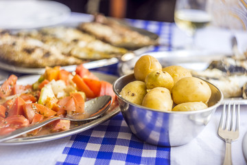Cooked baby potatoes as side dish to barbecued fish, Portugal