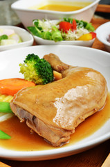 Braised chicken leg with vegetables on the plate