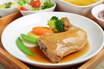 Braised chicken leg with vegetables on the plate