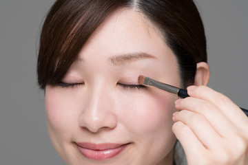 Fototapeta premium 化粧をする女性、アイシャドウ、パレット、コンパクト