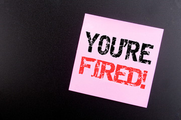 Word, writing You Are Fired. Business concept for Unemployed or Discharge written on sticky note, black background with copy space